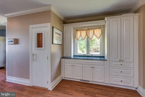 an empty room with wooden floor and cabinet