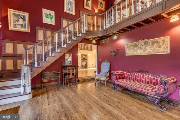 a view of a chairs and table in a hall with wooden floor