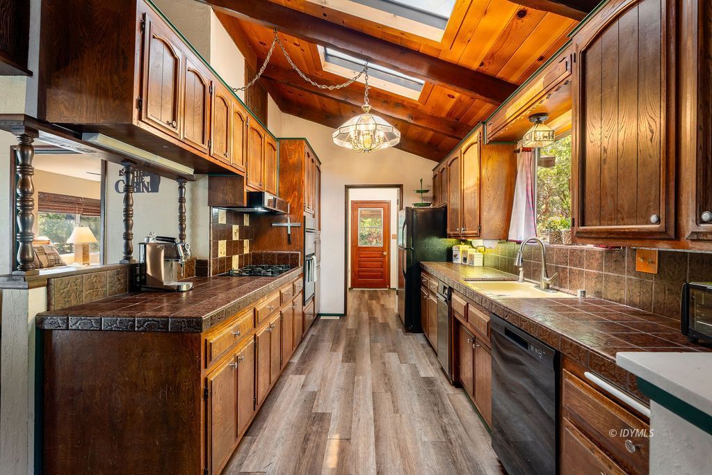 25580 Fir Street Idyllwild, CA 92549 - Photo 15 of 48 a kitchen with stainless steel appliances granite countertop lots of counter top space and wooden floor