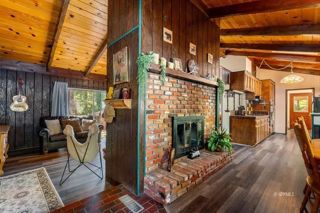 a living room with furniture a flat screen tv and floor to ceiling window