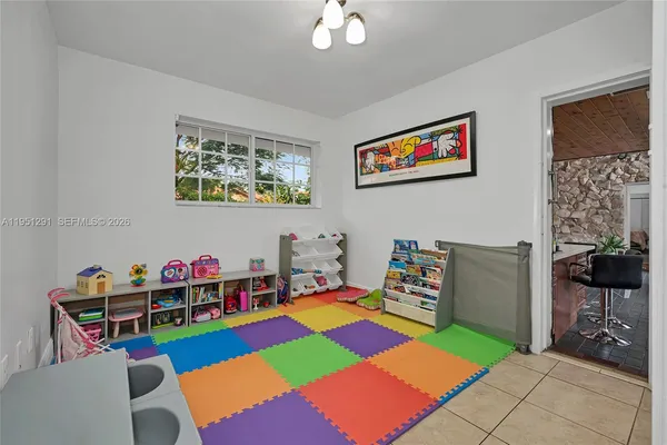 a living room with furniture and a baby crib