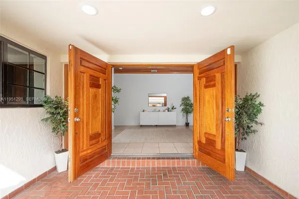 a view of a hallway with bathroom and front door