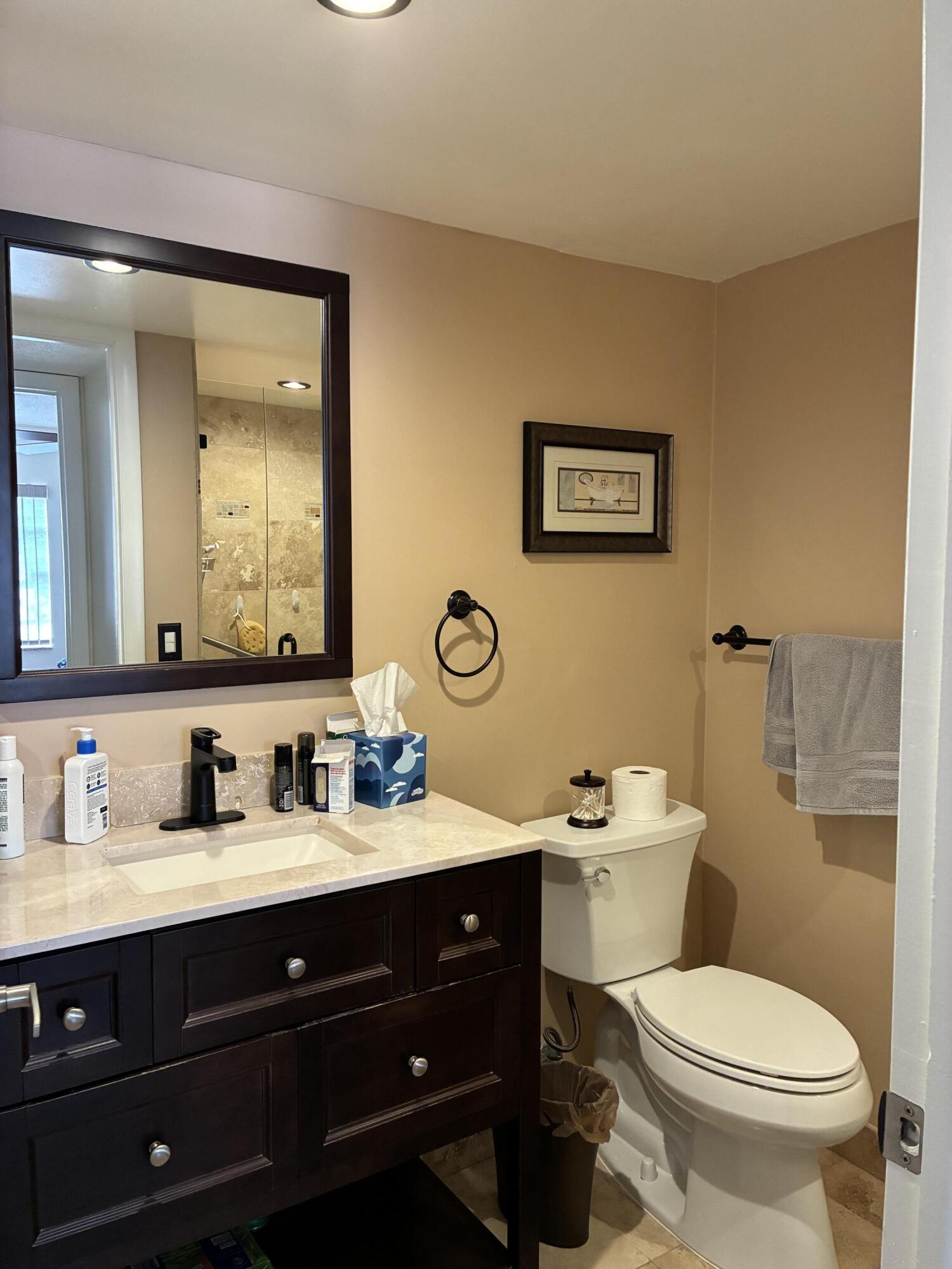 355 Normandy Lane Delray Beach, FL 33484 - Photo 11 of 33 a bathroom with a toilet sink and mirror