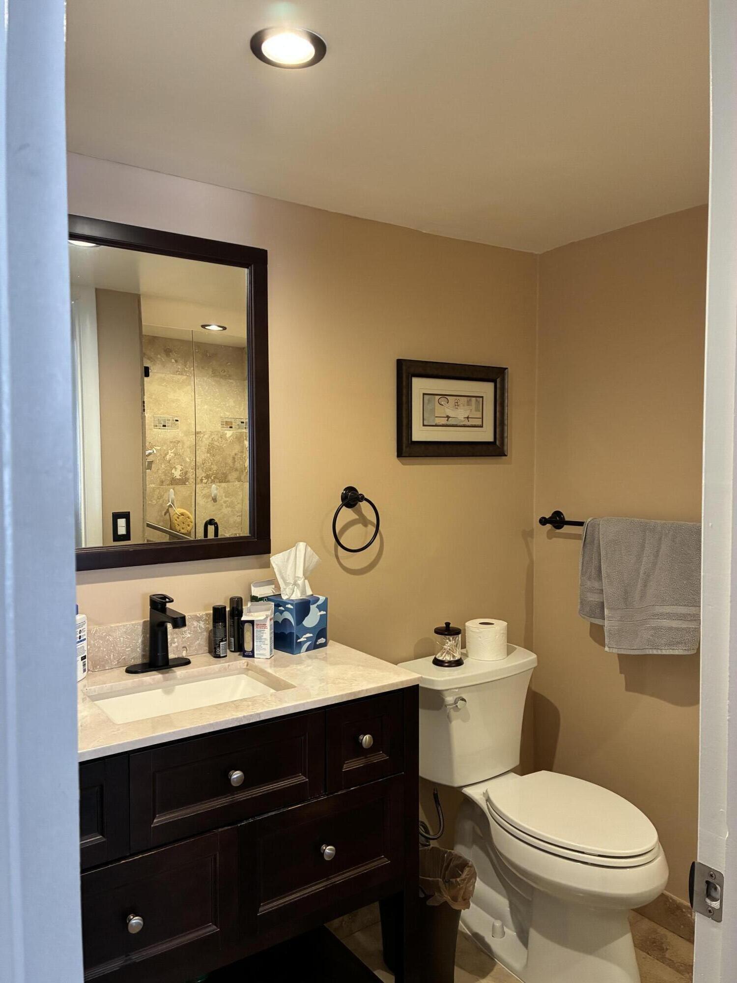 355 Normandy Lane Delray Beach, FL 33484 - Photo 12 of 33 a bathroom with a toilet a sink and mirror