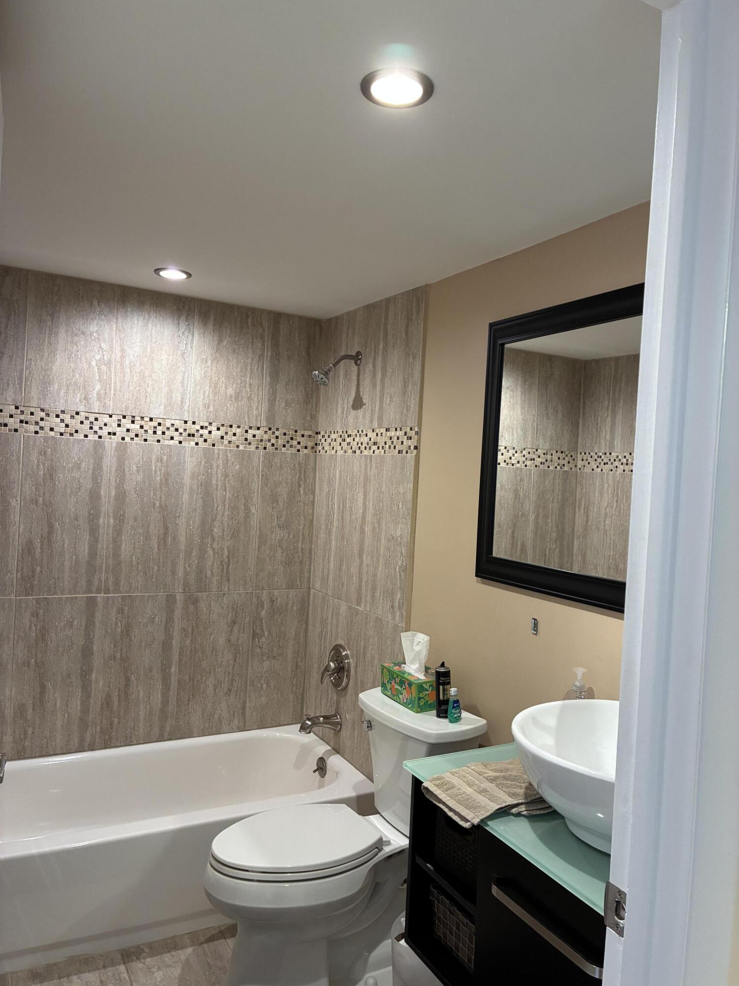355 Normandy Lane Delray Beach, FL 33484 - Photo 7 of 33 a bathroom with a granite countertop bathtub sink vanity mirror and toilet