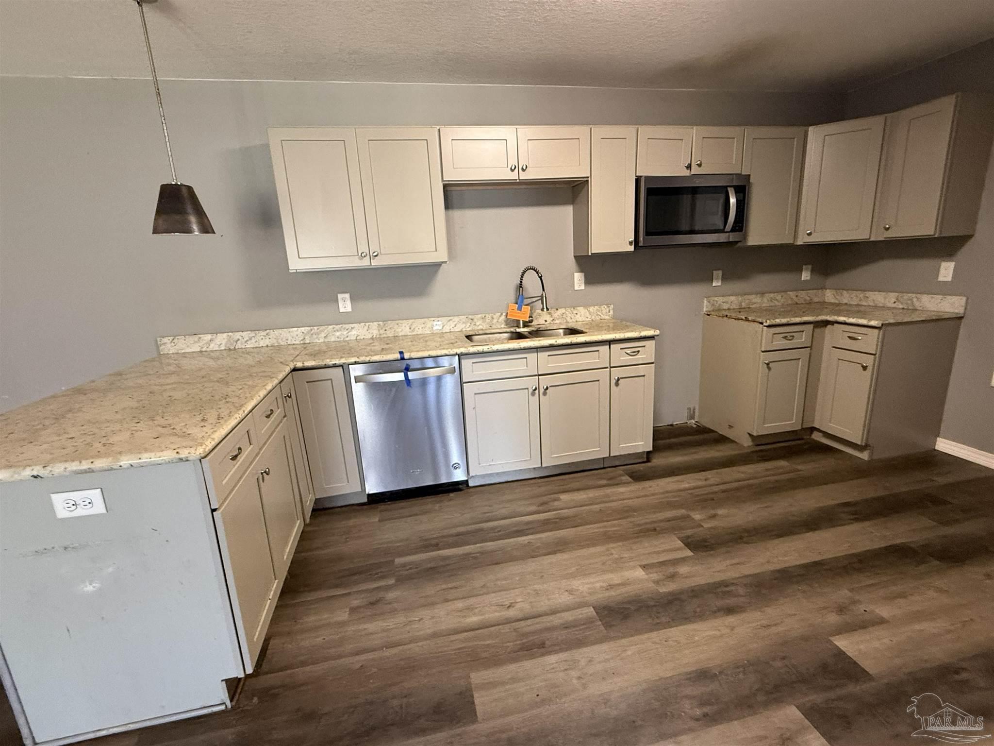 1009 Rachel Circle Cantonment, FL 32533 - Photo 4 of 11 a kitchen with granite countertop white cabinets sink and stainless steel appliances