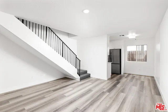 a view of a hallway with wooden floor and staircase