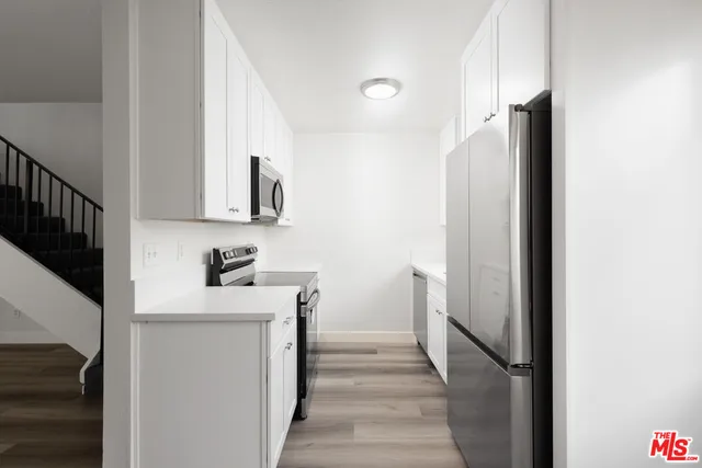 a kitchen with a refrigerator and a stove