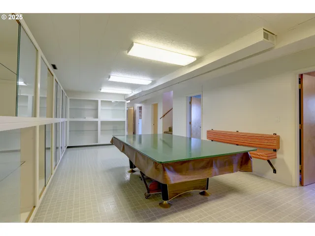 a room with furniture pool table and wooden floor