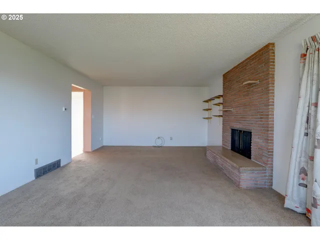 a view of empty room with a fireplace