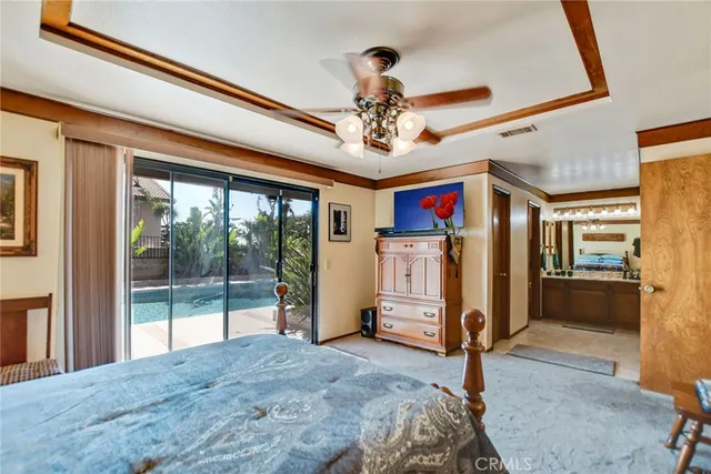 a view of a bedroom with wooden floor and ceiling fan