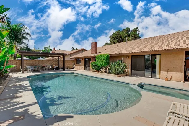 a view of a house with swimming pool and sitting area