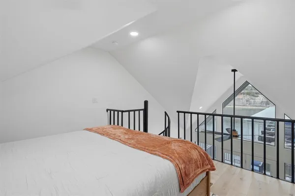 a bedroom with a bed and a wooden floor