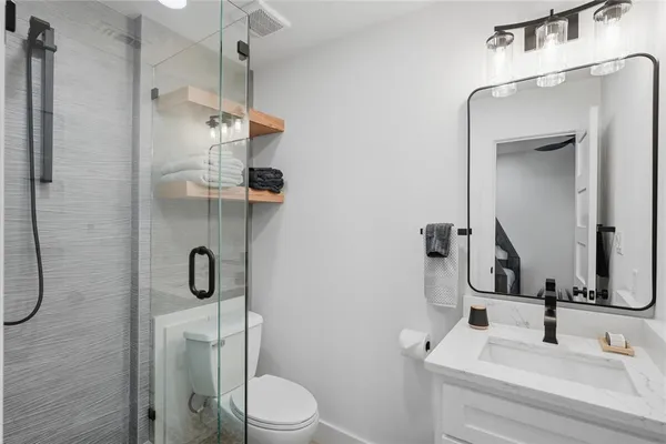 a bathroom with a sink a toilet and shower