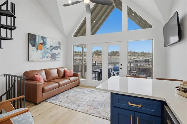 a living room with furniture a flat screen tv and large window
