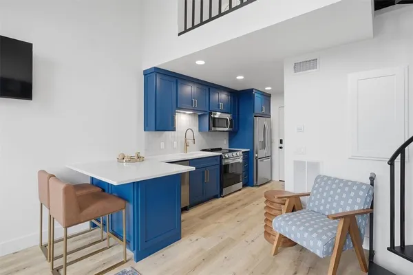 a kitchen with a table chairs refrigerator and a sink