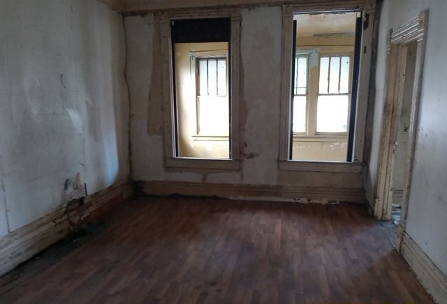 6531 South May Street Chicago, IL 60621 - Photo 3 of 12 an empty room with wooden floor and windows