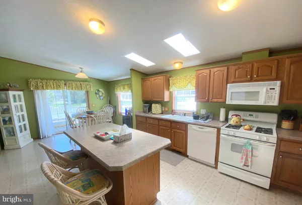 a kitchen with a stove a sink dishwasher and a refrigerator with wooden floor
