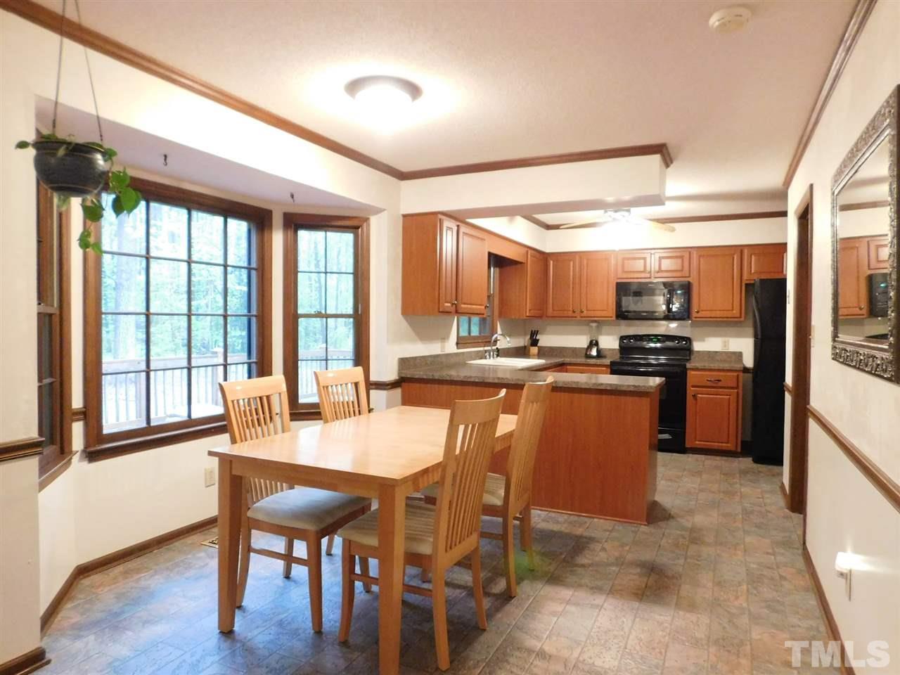3224 Brennan Drive Raleigh, NC 27613 - Photo 11 of 22 a dining room with stainless steel appliances kitchen island granite countertop furniture and a large window
