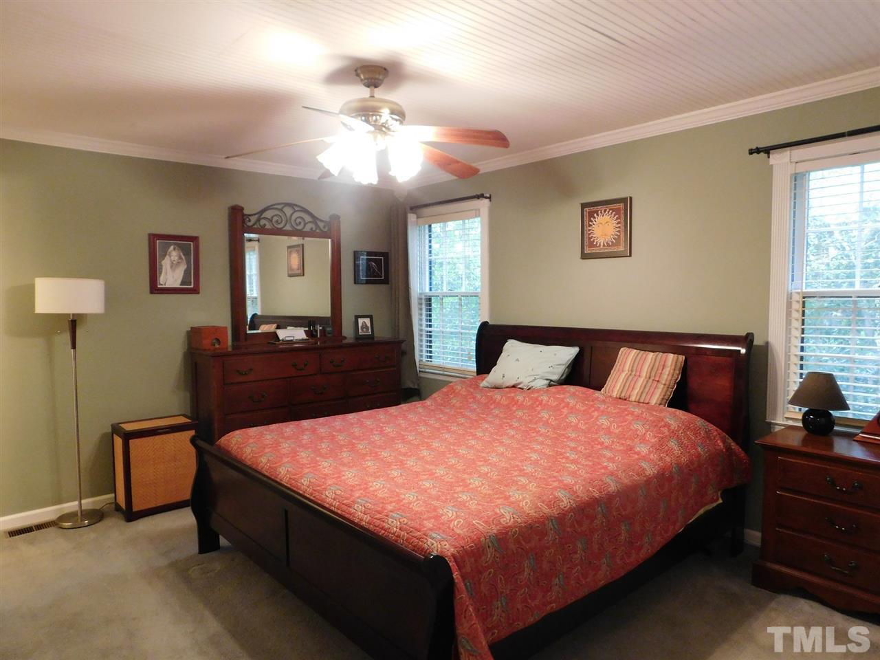 3224 Brennan Drive Raleigh, NC 27613 - Photo 13 of 22 a bedroom with a bed and a chandelier