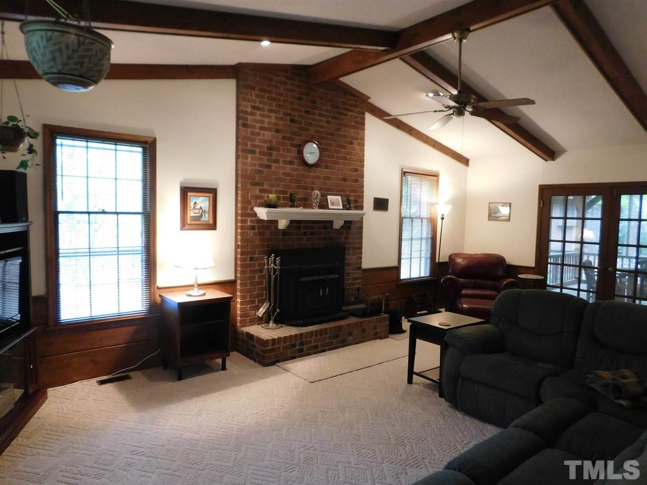 3224 Brennan Drive Raleigh, NC 27613 - Photo 6 of 22 a living room with furniture a flat screen tv and a fireplace