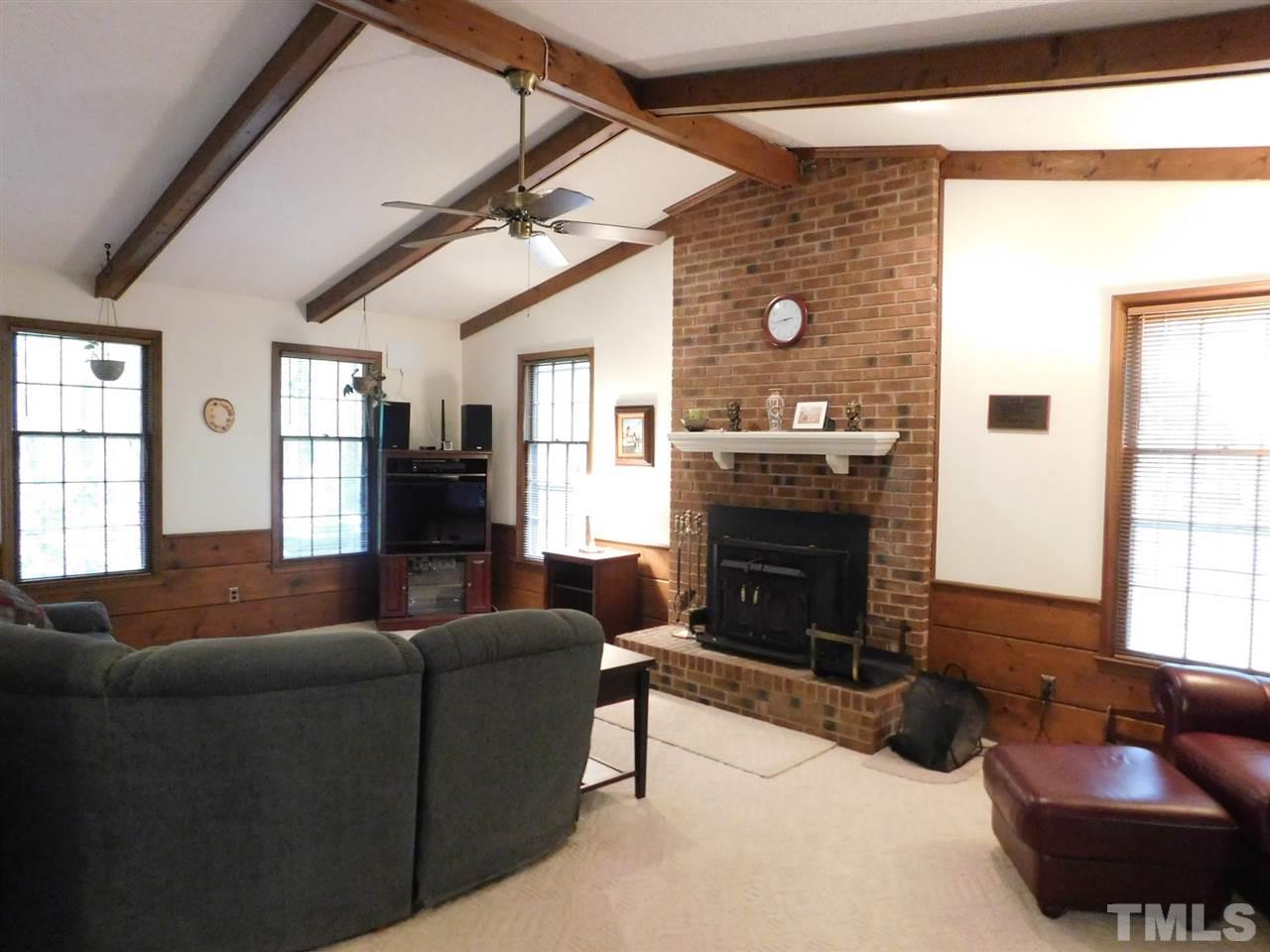 3224 Brennan Drive Raleigh, NC 27613 - Photo 8 of 22 a living room with furniture a fireplace and a large window