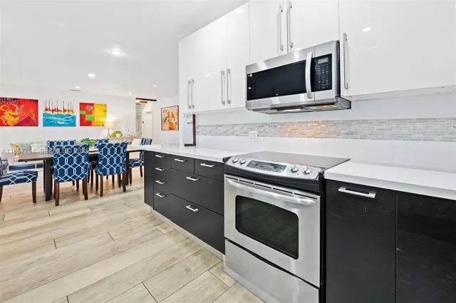 a kitchen with stainless steel appliances a stove microwave and cabinets