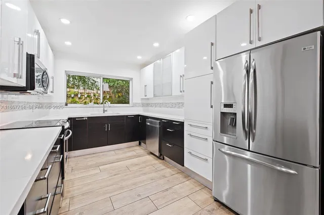 a kitchen with stainless steel appliances a refrigerator sink and cabinets