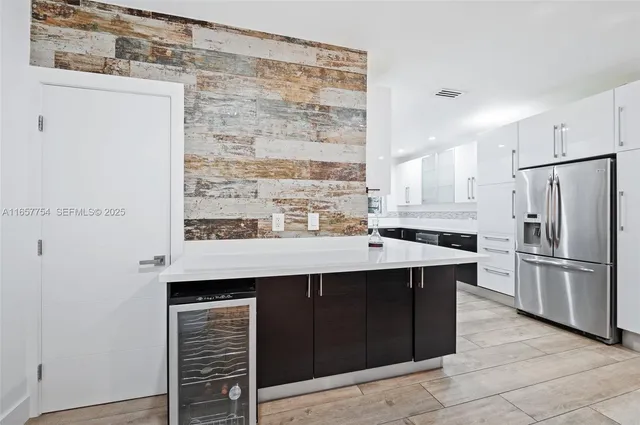 a kitchen with a sink refrigerator and cabinets