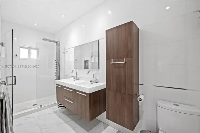 a bathroom with a sink mirror toilet and shower