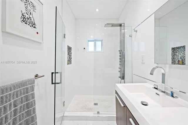 a bathroom with a bathtub shower sink and a mirror