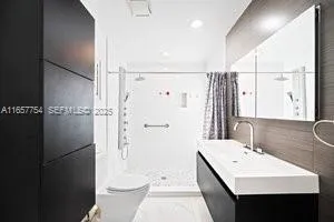a bathroom with a sink a toilet and shower