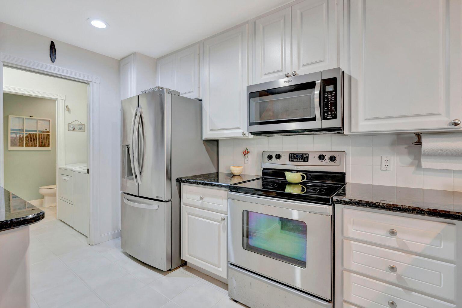 180 Freeport Drive Jupiter, FL 33458 - Photo 16 of 34 a kitchen with cabinets stainless steel appliances and a counter space