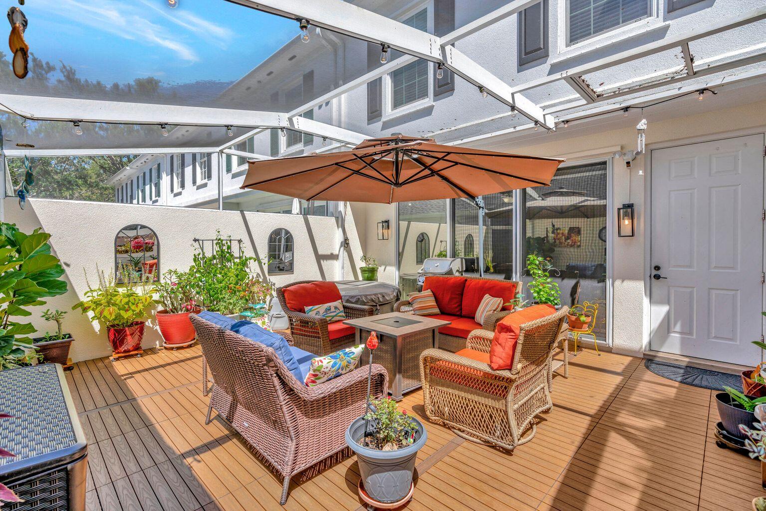 180 Freeport Drive Jupiter, FL 33458 - Photo 22 of 34 a view of a patio with a dining table and chairs under an umbrella