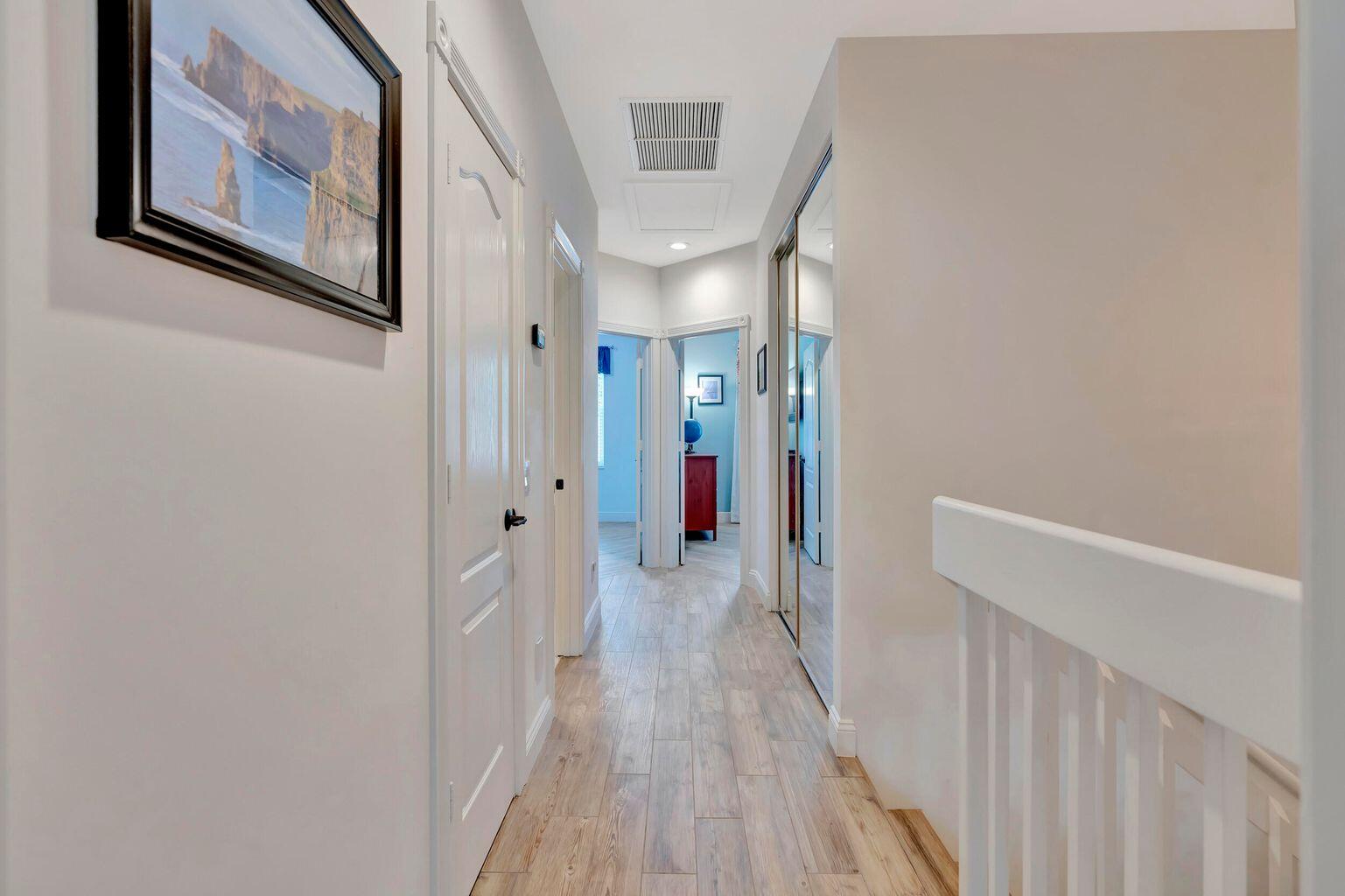 180 Freeport Drive Jupiter, FL 33458 - Photo 24 of 34 a view of a hallway with wooden floor and staircase