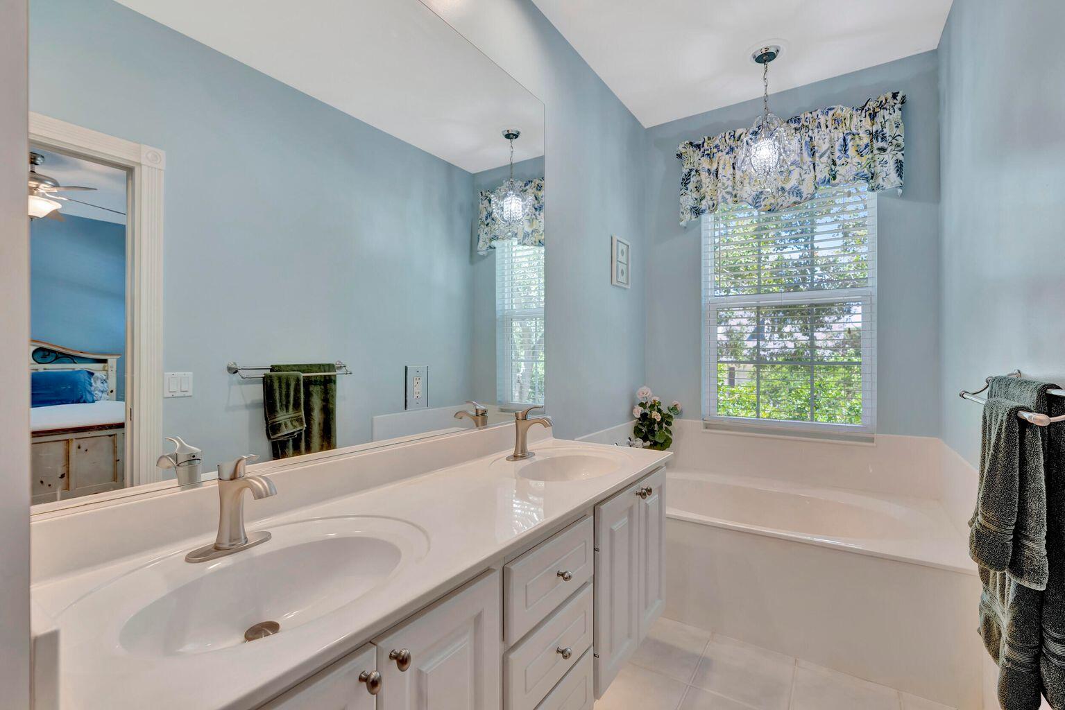 180 Freeport Drive Jupiter, FL 33458 - Photo 26 of 34 a bathroom with a tub sink and mirror