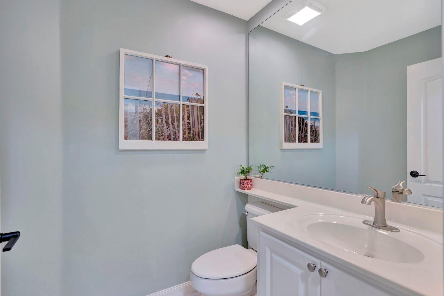 180 Freeport Drive Jupiter, FL 33458 - Photo 32 of 34 a bathroom with a toilet a sink and mirror