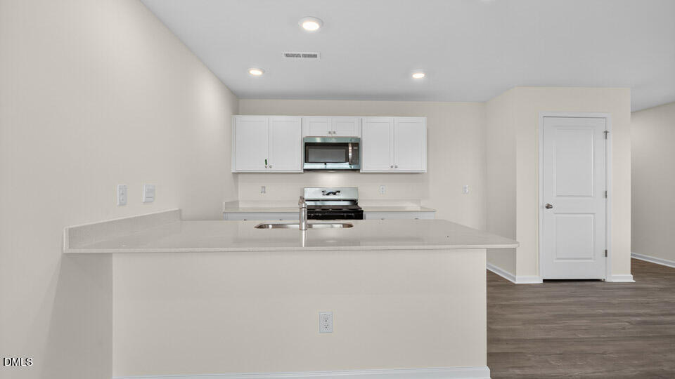 11 Red Clover Drive Angier, NC 27501 - Photo 8 of 33 a kitchen with kitchen island a sink a stove and cabinets