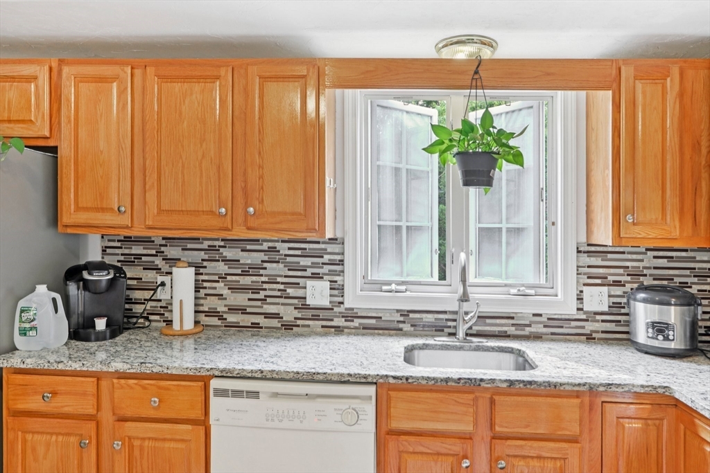 469 North Street Randolph, MA 02368 - Photo 19 of 42 a kitchen with granite countertop stainless steel appliances a sink window and cabinets