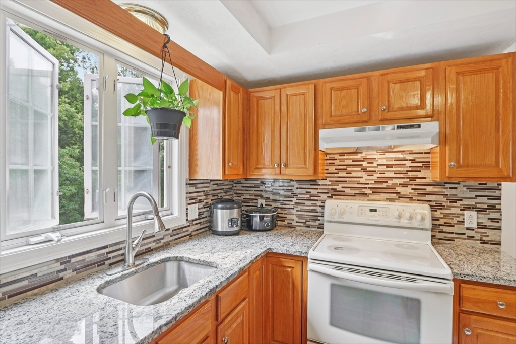 469 North Street Randolph, MA 02368 - Photo 20 of 42 a kitchen with stainless steel appliances granite countertop a sink stove and cabinets