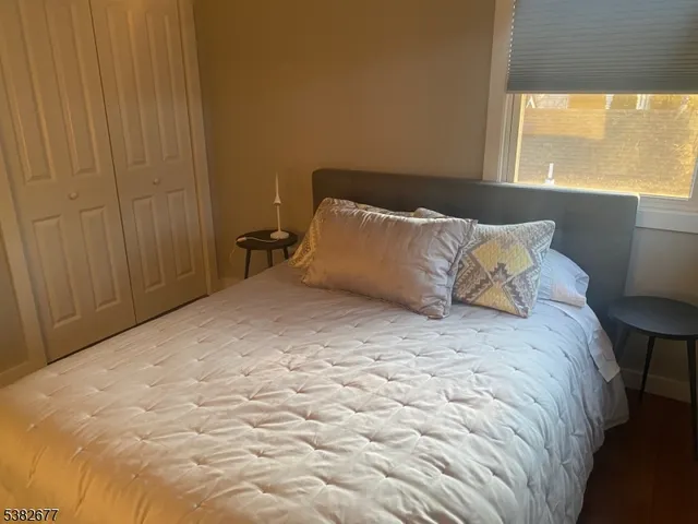a large bed sitting in a bedroom next to a window