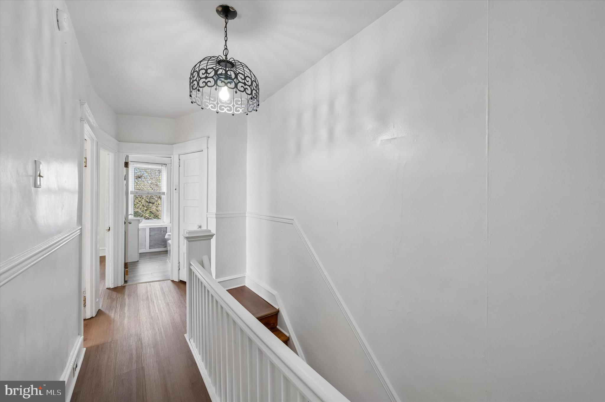 1008 East 18th Street Chester, PA 19013 - Photo 14 of 25 a view of a hallway with wooden floor and a chandelier