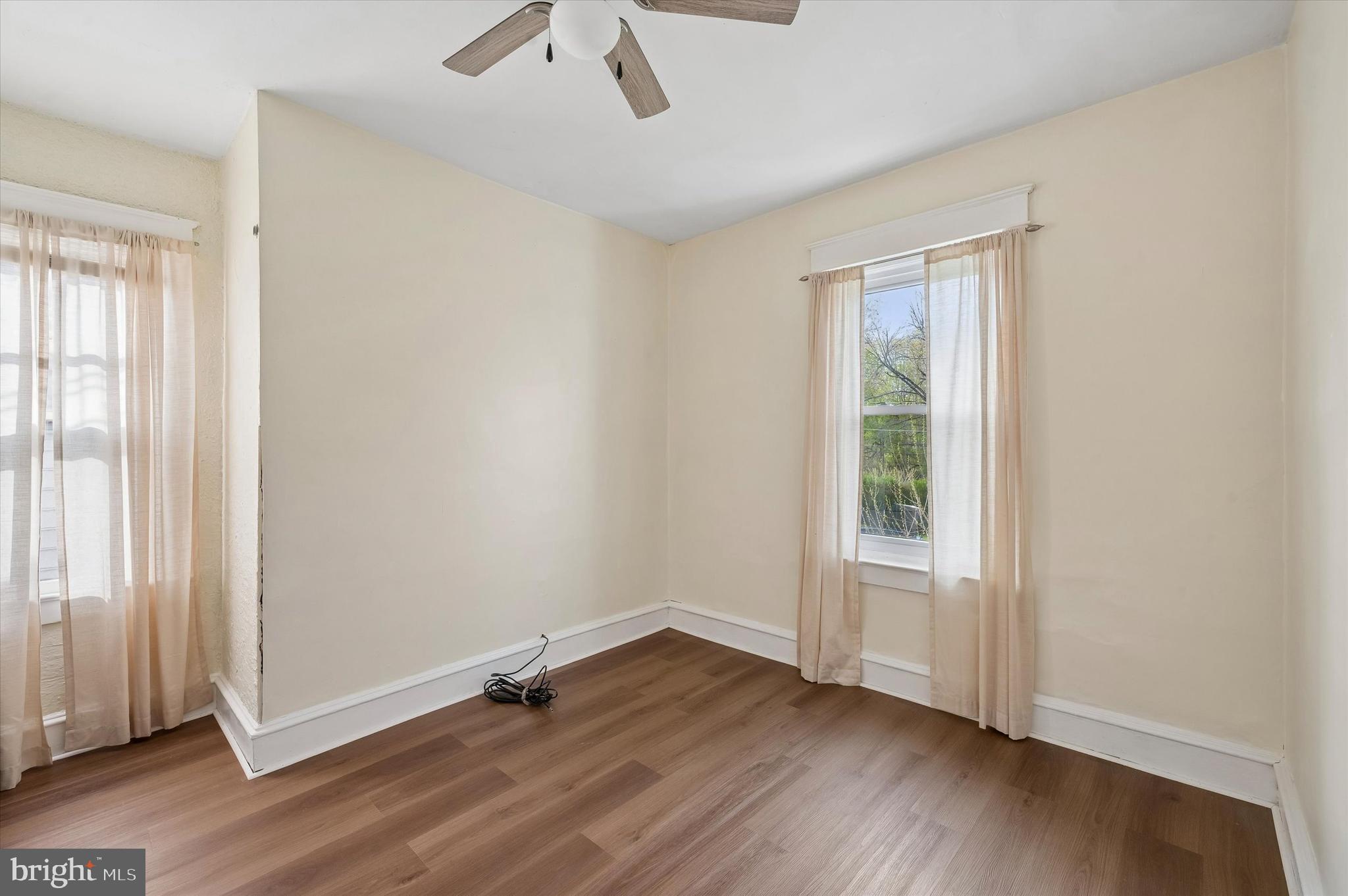 1008 East 18th Street Chester, PA 19013 - Photo 16 of 25 an empty room with wooden floor and windows