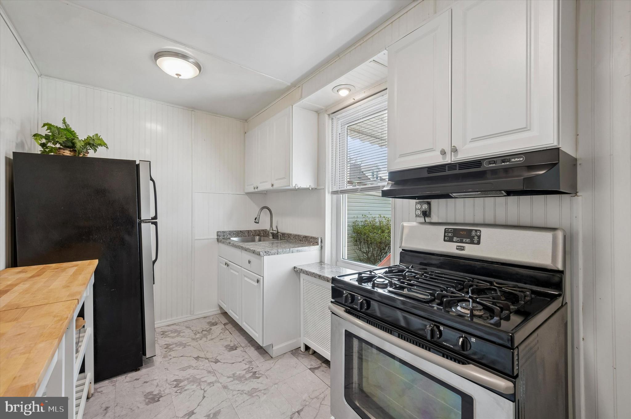 1008 East 18th Street Chester, PA 19013 - Photo 10 of 25 a kitchen with granite countertop a stove and a refrigerator