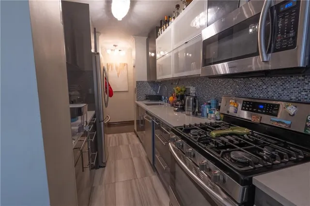 a kitchen with stainless steel appliances granite countertop a stove and a refrigerator