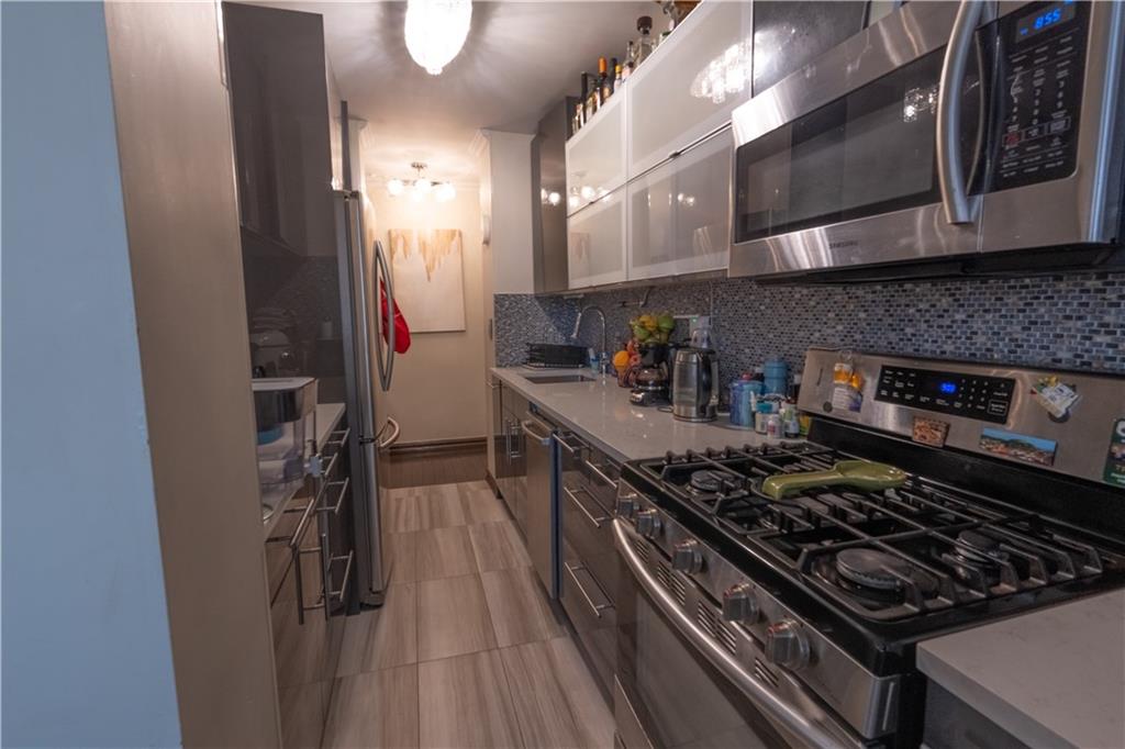 464 Neptune Avenue, Unit 3F Brooklyn, NY 11224 - Photo 6 of 15 a kitchen with stainless steel appliances granite countertop a stove and a refrigerator