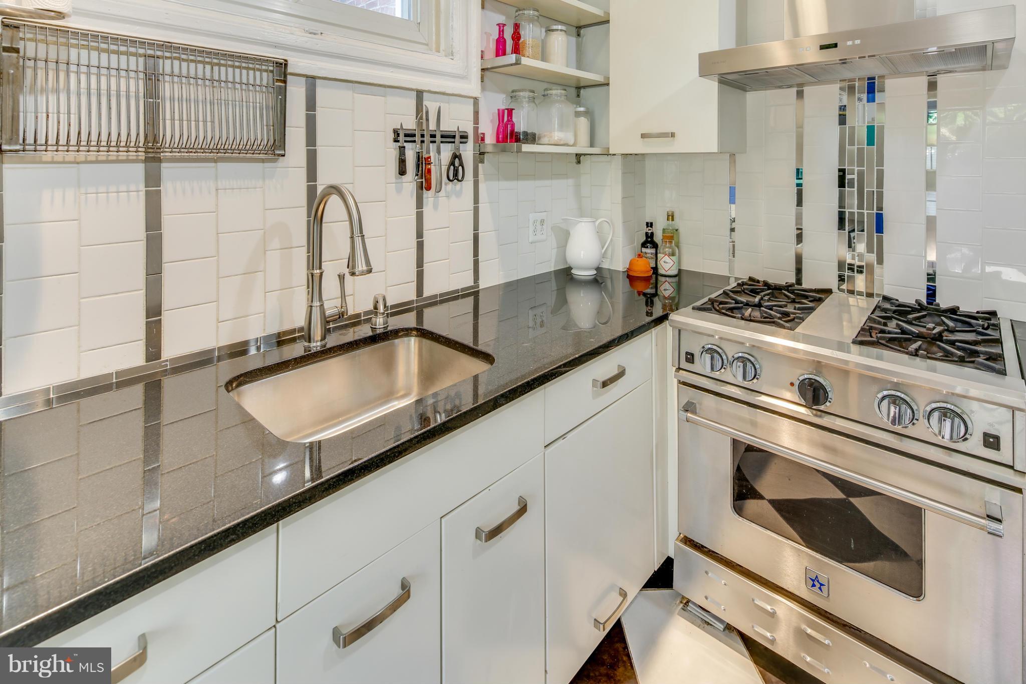 2317 Ontario Road Northwest Washington, DC 20009 - Photo 11 of 30 a kitchen with granite countertop cabinets stainless steel appliances and a counter space