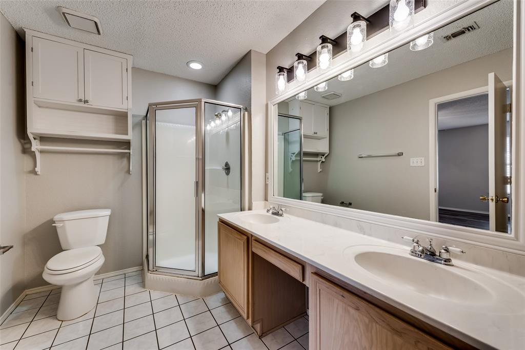 8129 Spruce Valley Drive Fort Worth, TX 76137 - Photo 11 of 19 a spacious bathroom with a granite countertop sink a toilet a mirror and shower