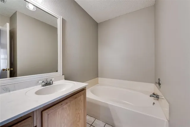 a bathroom with a granite countertop sink and a bathtub
