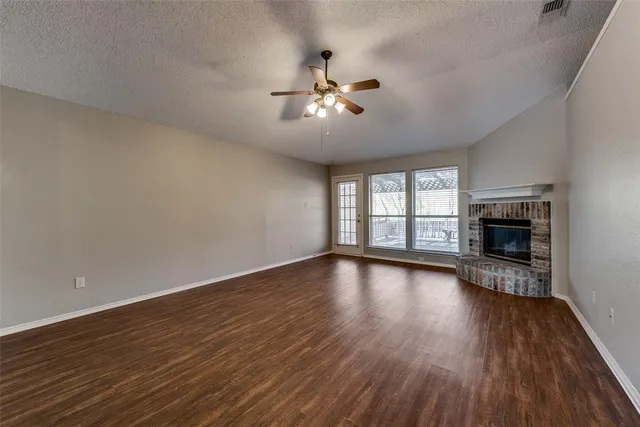 a view of empty room with wooden floor and fireplace
